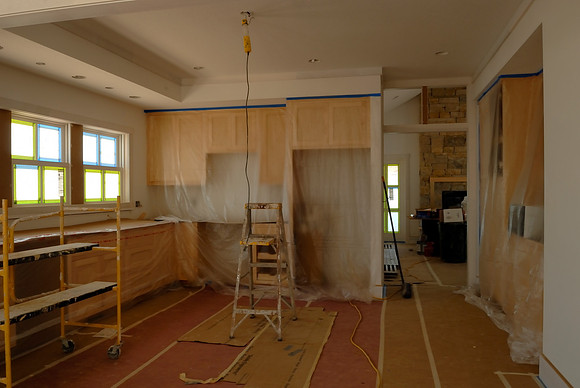 Cabinets all covered up for painting - nice chandelier...